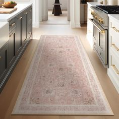 a large rug in the middle of a kitchen with an oven and counter tops on both sides