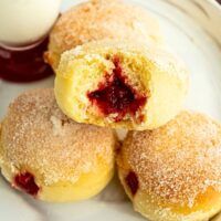 several pastries on a white plate with jam