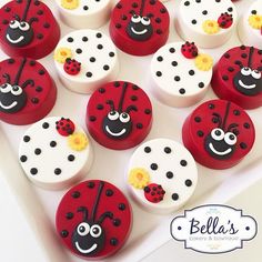 red and white cupcakes with ladybugs on them are sitting in a box