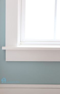 a white window sill sitting next to a blue wall