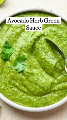 avocado herb green sauce in a bowl with a spoon and cilantro on the side