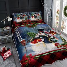 a christmas themed bed spread with santa clause and snowman on it, next to a window