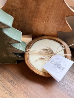 a wooden bowl with some soap on top of it and a tag in front of it