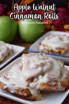 apple walnut cinnamon rolls with icing on white plates