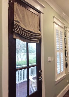 an open door leading to a porch with shutters on both sides and a window in the middle