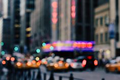 a city street filled with lots of traffic next to tall buildings and neon lights at night