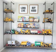 there are many toy trucks on the shelves in this room, and two framed pictures above them