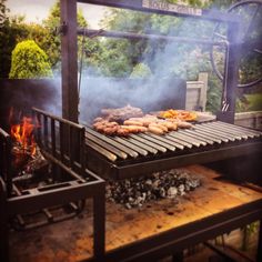 a grill with hot dogs and sausages cooking on it's burners outside