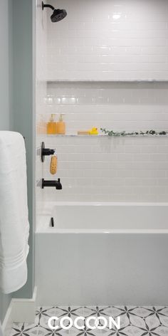 a white bath tub sitting next to a black and white tiled floor