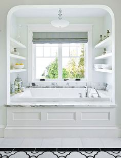 a white bathroom with black and white tile flooring on the bottom right hand corner