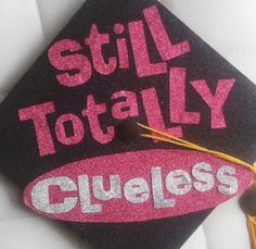 a black and pink graduation cap with the words still totally clueless written on it