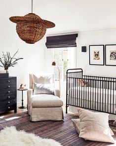 a living room with a couch, chair and baby crib in the middle of it