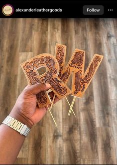 a person holding up some wooden letters