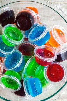 there are many different colored jello cups in the bowl