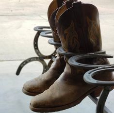 several pairs of cowboy boots sitting on top of a metal table next to each other