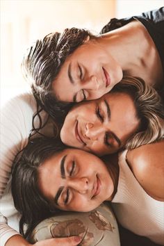 three women cuddle together on the back of a couch