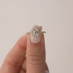 a woman's hand with a diamond ring on her finger, showing the center stone