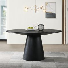 a black table with plates and glasses on it in the middle of a living room