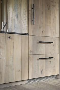 a kitchen with wooden cabinets and black handles