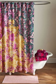 a bathroom with a bathtub, rug and shower curtain