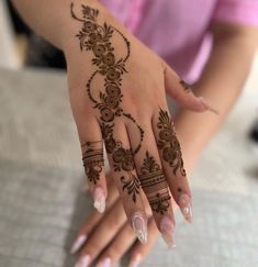 a woman's hand with henna tattoos on it