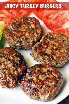 four hamburger patties on a white plate with tomatoes and corn in the background, text juicy turkey burgers