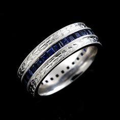 a white gold ring with blue sapphires and filigreets on the sides