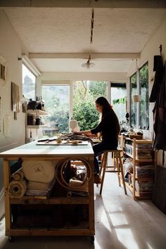 a woman sitting at a table working on some type of project in her home office