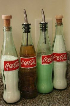 three coca - cola bottles are lined up next to each other on a counter top