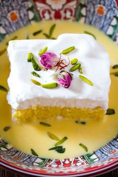 a piece of cake with white frosting and flowers on it sitting on a plate