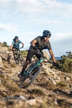 two mountain bikers riding down a rocky trail