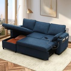 a living room with a blue couch and a pull out sofa bed in the middle