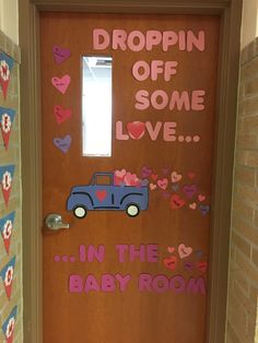 a door decorated with paper hearts and a blue car on it that says dropin'off some love in the big baby room