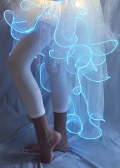 a woman in white and blue light up leggings with her legs spread out