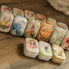 there are many small tins that have flowers on them, all lined up next to each other