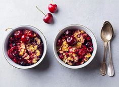 two bowls filled with fruit and topped with granola