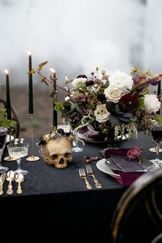 the table is set with silverware, candles and flowers in vases on it