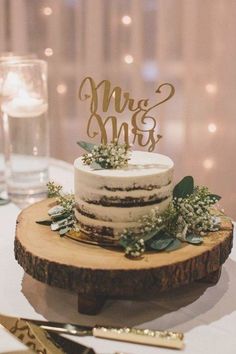 a wedding cake sitting on top of a wooden slice