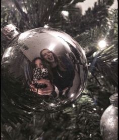 a christmas ornament with a woman's reflection in it