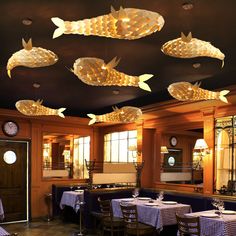 a dining room with several fish lights hanging from the ceiling