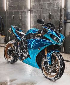 a blue and black motorcycle parked in a garage