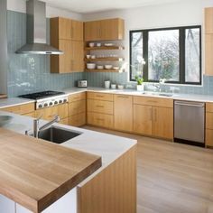 a modern kitchen with wooden cabinets and stainless steel appliance in the center island