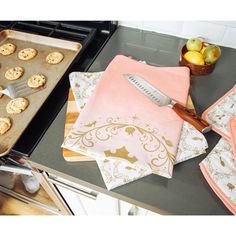 a table topped with cookies and an oven mitt next to a pan filled with food