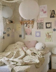 a bedroom with white walls and pictures on the wall