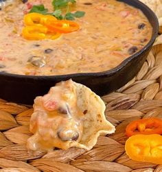 tortilla chips and salsa in a bowl on a woven place mat next to an orange bell pepper