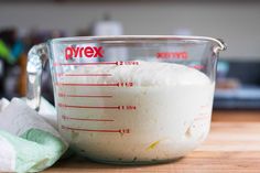 a measuring cup filled with flour on top of a wooden table