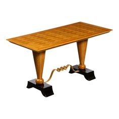 a wooden table with two black legs and a chess board on the top, as well as a gold ribbon