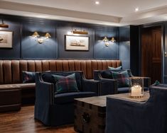 a living room with couches, chairs and lamps on the wall above them is lit by candles