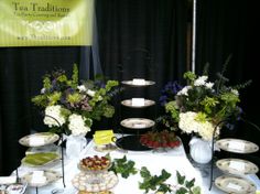 a table topped with lots of different types of food on plates and trays filled with fruit