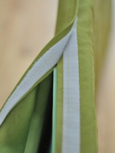 the side of a green and white tie on a wooden table with it's end partially closed